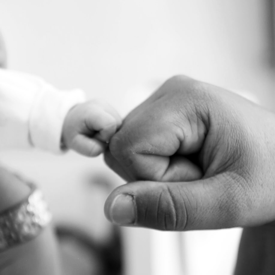 Infant hand and adult hand