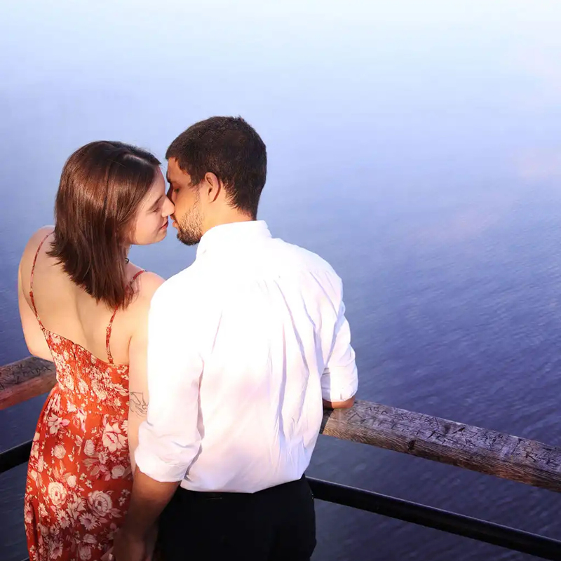 Young couple embraces each other looking out at a lake